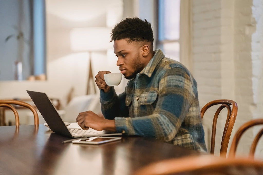 Man working on the computer sipping coffee