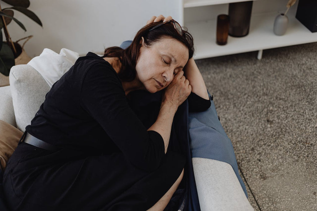 A woman trying to sleep on the couch